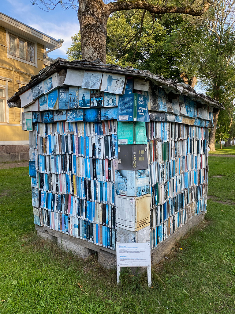 A small house structure made entirely out of old books.